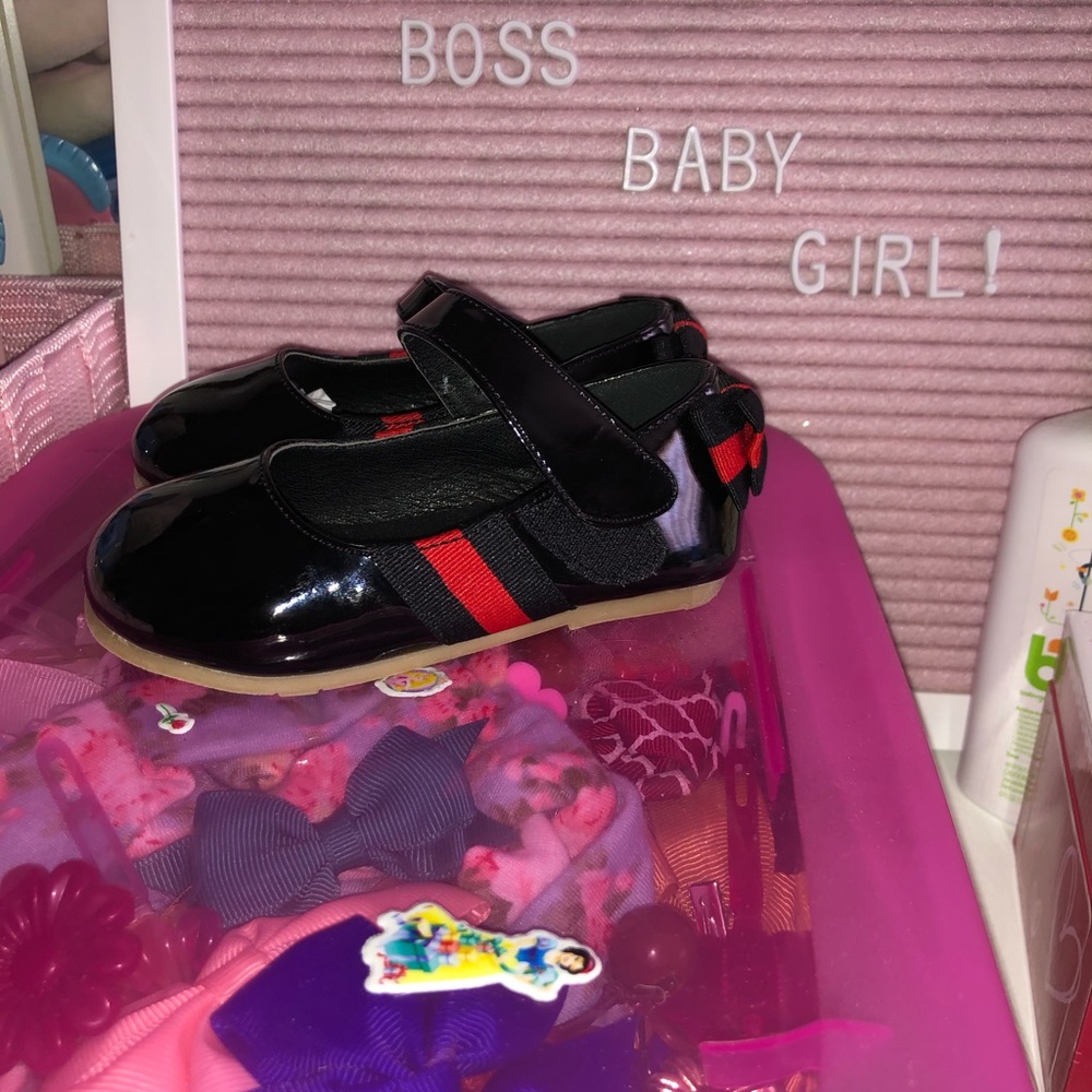 Black patent leather strap over shoe.